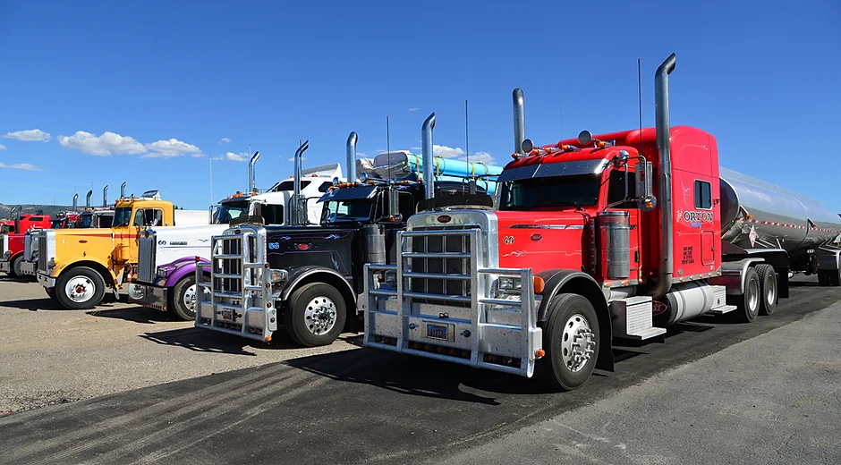 A row of colorful semi-trucks parked in a lot.